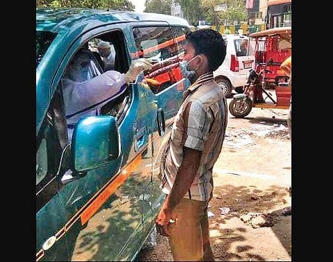 A healthcare worker tests a man in North district of New Delhi | EXPRESS