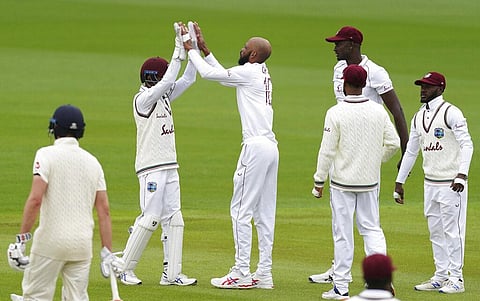 West Indies' Roston Chase, third left, celebrates with teammates the dismissal of England's Rory Burns during the first day of the second cricket Test match between England and West Indies at Old Trafford in Manchester, England, Thursday, July 16, 2020. (