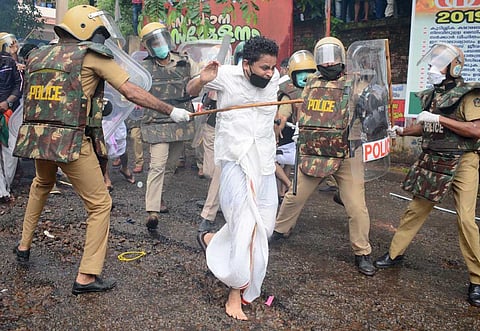 Police lathicharging a Yuva Morcha activist during a protest march to the Kozhikode collectorate demanding the resignation of Chief Minister Pinarayi Vijayan. (Photo | Manu R Mavelil, EPS)