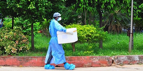A health worker carrying the collected samples for testing at the government ENT Hospital in Visakhapatnam. (Photo | G Satyanarayana, EPS)