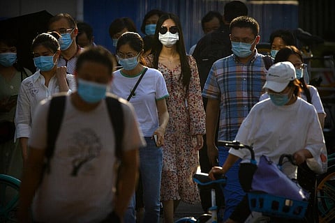 People wearing face masks to protect against the coronavirus wait to cross an intersection in the central business district of Beijing, Wednesday, July 15, 2020. (Photo | AP)