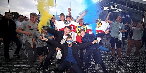 Leeds United fans celebrate outside Elland Road, Friday, July 17, 2020, on Leeds, England, after Huddersfield Town beat West Bromwich Albion to seal their promotion to the Premier League. (Photo | AP)