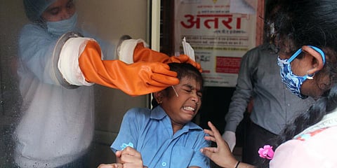 A health worker collects a swab sample for COVID-19 RT-PCR test at Urban Primary Health Centre, Gandhi Nagar, in Gurugram. (Photo| ANI)