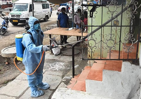 Corporation worker goes to door to door and sanitises the shops and houses at Velachery main road. (Photo | Ashwin Prasath/EPS)