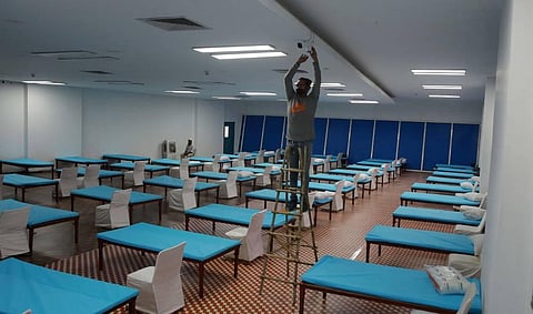 Workers install beds inside a newly created COVID centre set up at Commonwealth Games Village CWG indoor stadium near Akshardham in New Delhi on Wednesday.  (Photo | Shekhar Yadav/EPS)