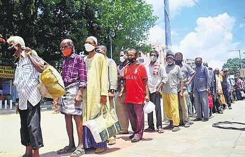 Daily wage labourers and homeless people line up to get food, in front of Victoria Hospital in Bengaluru on Monday | PANDARINATH B