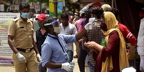 Volunteers check the body temperature of customers entering Ernakulam's Broadway market. (Photo | Albin Mathew, EPS)