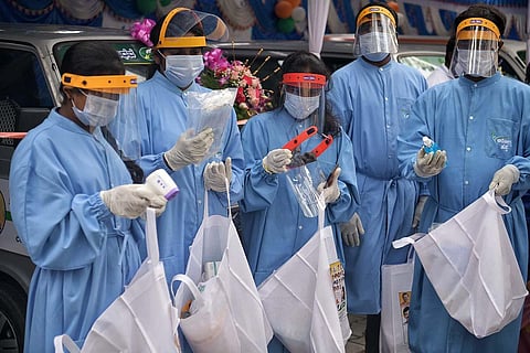 Health workers receive safety gear under the state Congress’ Arogya Abhaya Hasta scheme, in SG Palya, Bengaluru. (Photo | Meghana Sastry, EPS)