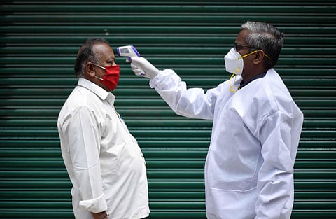 A health worker checking the temperature at the fever camp near Chepauk in Chennai. (File Photo | R Sathish Babu/EPS)