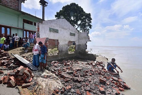 Villagers stand next to a school and mosque that collapsed on the bank of Brahmaputra river owing to sea erosion at Bhurbandha village in Nagaon district Saturday July 25 2020. (Photo | PTI)
