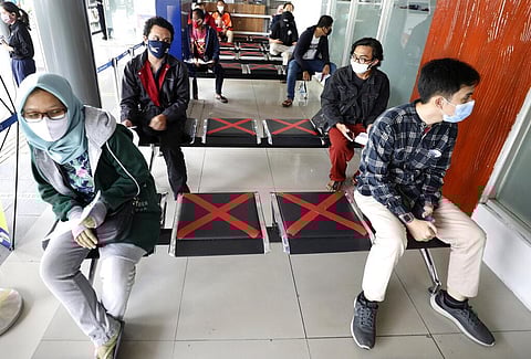 People sit spaced apart as they wait for a coronavirus test required to board long-distance trains the at Senen Train Station in Jakarta, Indonesia. (Photo | AP)
