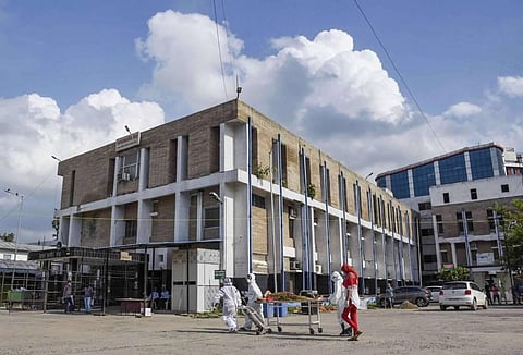 Medics wearing PPE kits shift a COVID-19 patient to an emergency ward at Nalanda Medical College and Hospital NMCH in Patna Wednesday July 22 2020. (Photo | PTI)