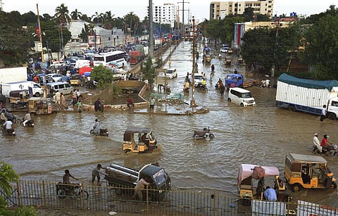 Vehicles drive through a flooded road after a heavy rainfall in Karachi, Pakistan, Monday, July 27, 2020. (Photo | AP)