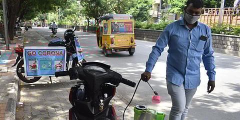 A cab driver who was out of business is now disinfecting vehicles to survive at Minister Road in Hyderabad on Monday. (Photo| S Senbagapandiyan, EPS)