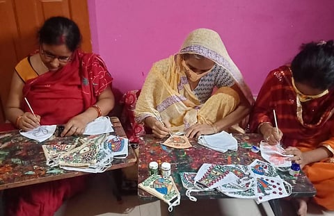 Artisans involved in making masks with Madhubani paintings. (Photo | Express)
