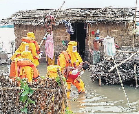 National Disaster Response Force personnel rescue villagers from a flood-affected area in Assam’s Dhubri district on Tuesday (Photo | PTI)