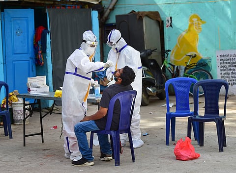 Health workers collects sample from a person for COVID-19 test via Rapid Antigen Testing in a slum area. (Photo| PTI)