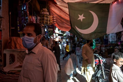 A man wearing a face mask as a preventive measure against the COVID-19 coronavirus shops at the Raja Bazar in Rawalpindi. (Photo| AFP)