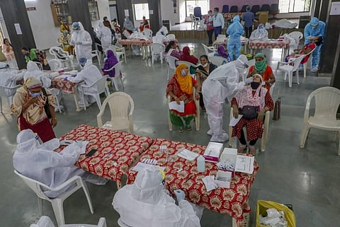 Healthcare workers wearing personal protective equipment PPE kits collect swab samples of municipal school teachers for COVID-19 test in Ahmedabad. (Photo | PTI)