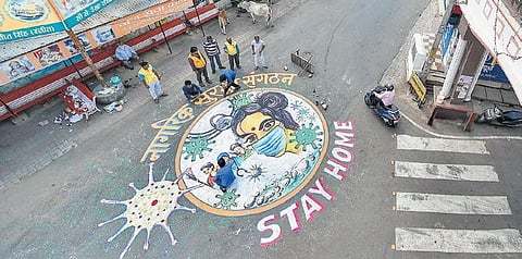 Nagrik Suraksha Sangathan volunteers paint a graffiti on a road to create awareness on coronavirus in Lucknow (File Photo | PTI)