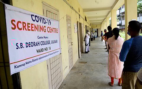 People stand in a queue as they wait for their turn to give swab samples for COVID-19 test at a hospital in Guwahati Saturday July 4 2020. (Photo | PTI)