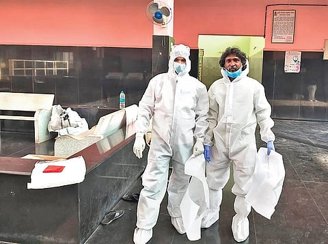 Bruhat Bengaluru Mahanagara Palike workers put on PPE kits before cremating those who have died from Covid-19, on Saturday | Express