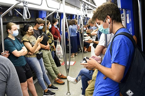 People wear protective masks in a metro during the coronavirus outbreak in Lausanne, Switzerland, Monday, July 6, 2020. In Switzerland, from Monday, people aged 12 and over must wear a mask in all public transport, trains, trams and buses, as well as in c