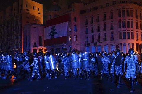 Riot police march toward demonstrators during an anti-government protest following Tuesday's massive explosion which devastated Beirut, Lebanon. (Photo | AP)
