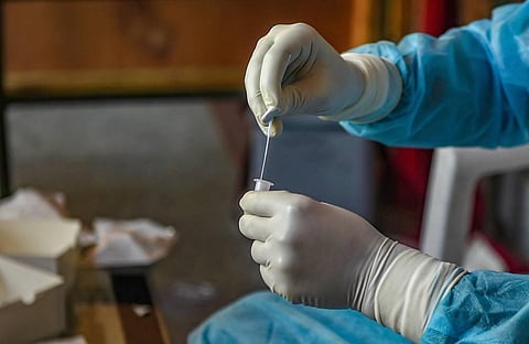 A health worker collects samples in a container for COVID-19 test via Rapid Antigen Testing in Srinagar Monday Aug. 10 2020. (Photo | PTI)