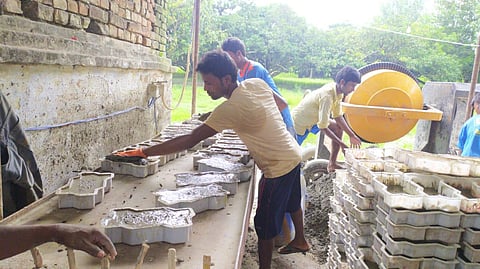 Migrants working in Bihar's West Champaran making pavers blocks.
