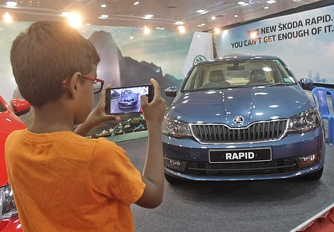 A young visitor to the Express Auto Expo clicks a snap of Skoda Rapid.  (File Photo | Ashwin Prasath)