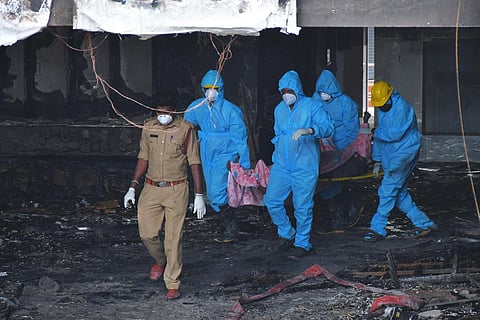 Fire fighters and medical staff transport bodies of deceased coronavirus patients to mortuary from Swarna Palace in Vijayawada. (Photo | Prasant Madugula, EPS)