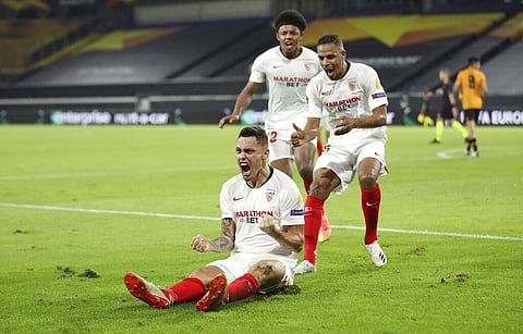 Lucas Ocampos, bottom left, celebrates with his teammate after scoring his side's opening goal during the Europa League quarterfinal soccer match between Wolves and Sevilla. (Photo | AP)