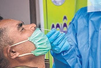 A health worker collects swab sample from a person for rapid antigen test at Unit-3 Urban Primary Health Center in Bhubaneswar on Tuesday (Photo | EPS)