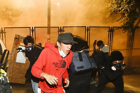 Demonstrators back away from tear gas during a protest at the Mark O. Hatfield United States Courthouse in Portland. (Photo | AP)