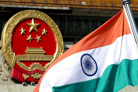 In this Oct. 23, 2013, file photo, an Indian national flag is flown next to the Chinese national emblem outside the Great Hall of the People in Beijing. (Photo | AP)