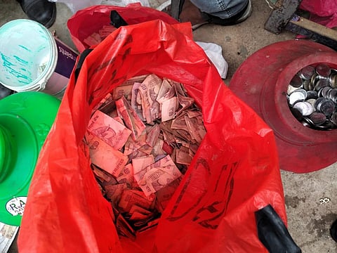 Police found about Rs 2 lakh in currency notes and coins among the heap of waste in the makeshift house of the ragpicker