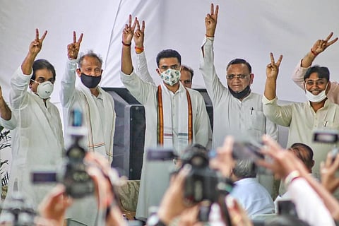 Rajasthan Chief Minister Ashok Gehlot along with senior Congress leaders Sachin Pilot Avinash Pandey and others flashes victory signs at CM residence in Jaipur Thursday. (Photo | PTI)