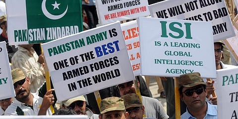 Pakistanis hold placards as they march during a rally in favour of Pakistan's army and Inter-Services Intelligence (ISI) in Karachi. (File photo| AFP)