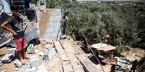 A Palestinian boy inspects the damage in his family home following Israeli airstrikes in Buriej refugee camp, central Gaza Strip. (Photo | AP)