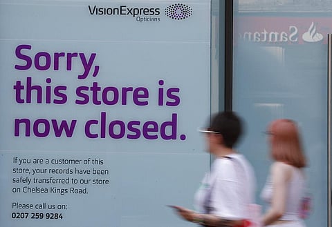Pedestrians pass by a closed branch of Vision Express in Kensington, London, Wednesday, Aug. 12, 2020. (Photo | AP)