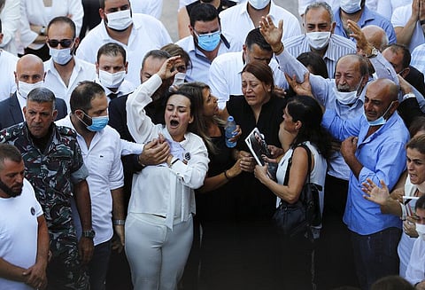 Relatives of three of ten firefighters who were killed during the Aug. 4 explosion mourn during their funeral. (Photo | AP)