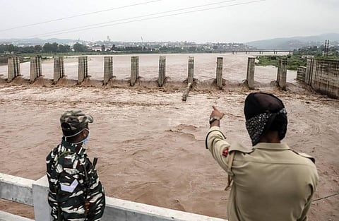 Security personnel have a look of the flooded Tawi River after heavy rains in Jammu (Photo | PTI)