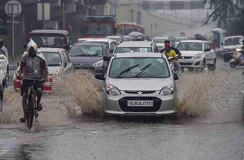 Vehicles ply on a waterlogged road after heavy monsoon rains in New Delhi Wednesday. (Photo | PTI)