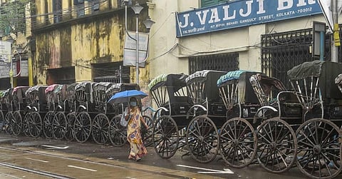 A woman walks past hand-pulled rickshaws parked along a road during the biweekly lockdown in the wake of coronavirus pandemic in Kolkata Friday Aug. 21 2020. (Photo | PTI)