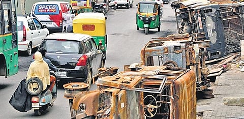 Life has gradually returned to normal in DJ Halli, even as the charred remains of vehicles litter the roadside, in Bengaluru on Thursday | Meghana Sastry
