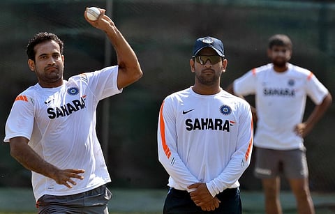 Irfan Pathan (L) delivers a ball as Mahendra Singh Dhoni (C) looks on during a training session. (Photo | AFP)