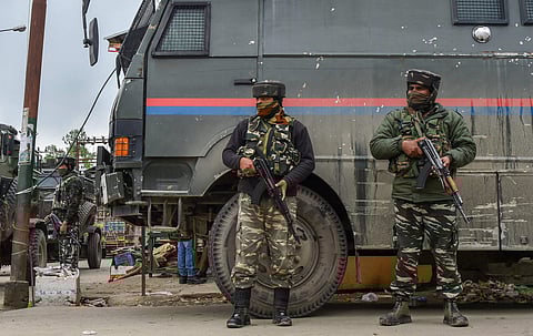 Security personnel stand guard during an encounter with terrorists at Sopore, in Baramulla district.