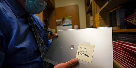 Tom Baumgarten, superintendent of the Morongo County School District, looks at a laptop with a cracked screen at Twentynine Palms Junior High School. (Photo| AP)