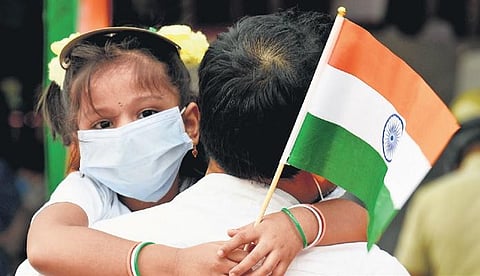 A young girl on her father’s shoulders carries the Tricolour during the 74th Independence Day celebrations at Parade Grounds on Saturday